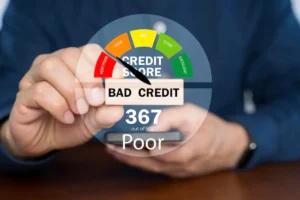 A person holding a block reading BAD CREDIT with a credit score gauge indicating a poor score of 367 out of 900.