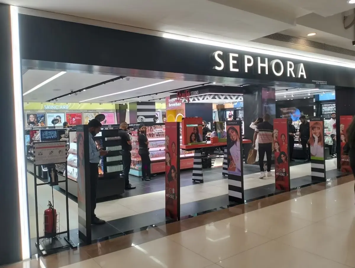 A vibrant Sephora store entrance with displays of beauty products and promotional posters, showcasing various brands and cosmetics.