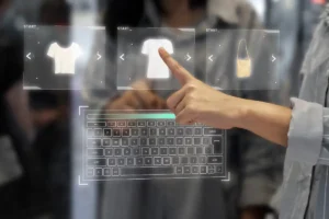 A hand interacts with a virtual touchscreen displaying clothing items and a digital keyboard in a futuristic shopping experience.